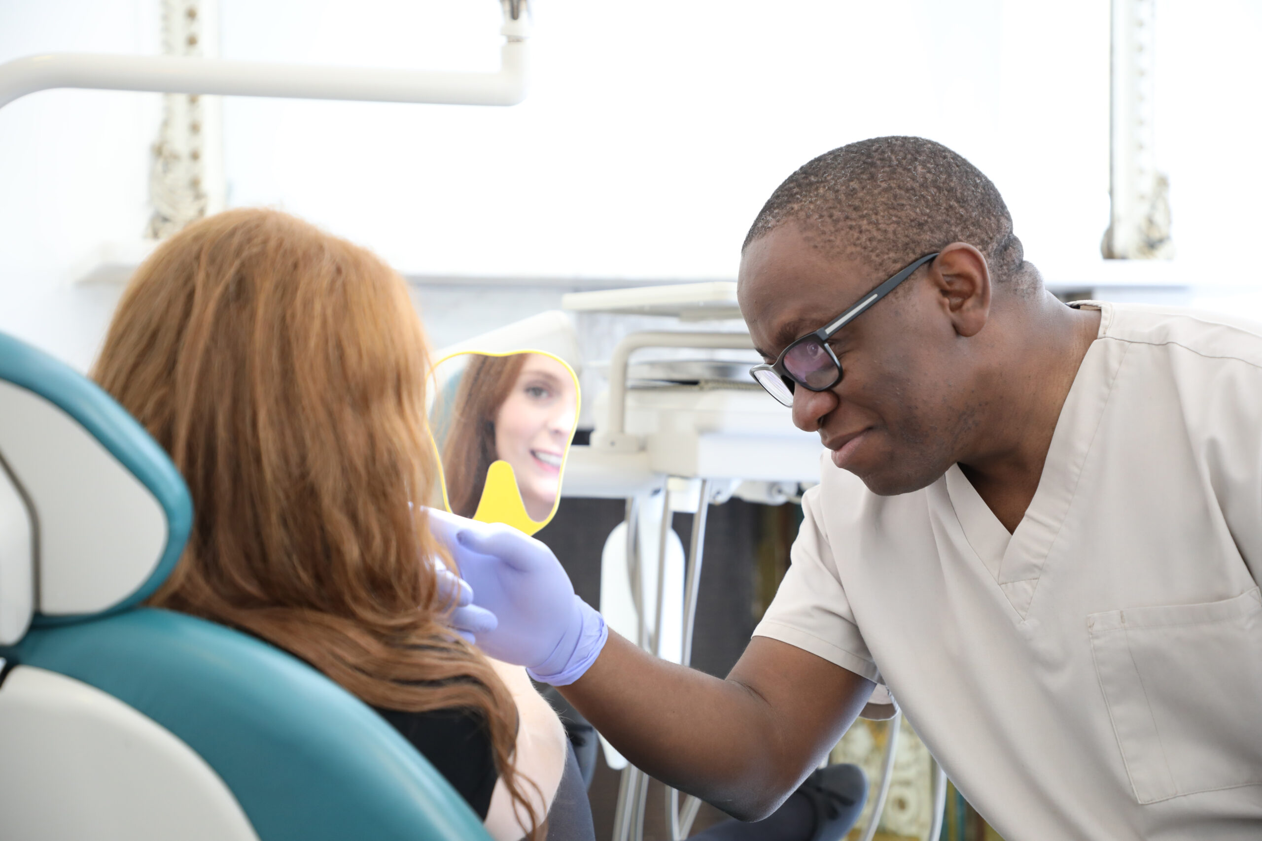 Dr Opeoluwa Sodeinde showing a patient her completed dental implants at London Dental Specialists
