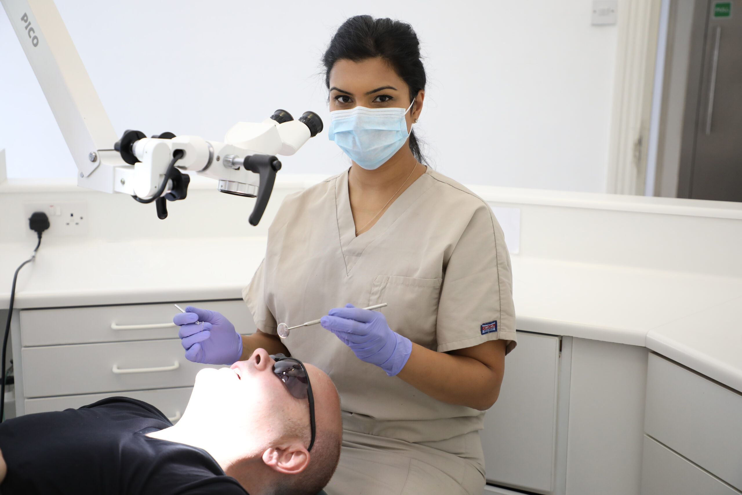 Specialist treating a patient under the operating microscope at London Dental Specialists